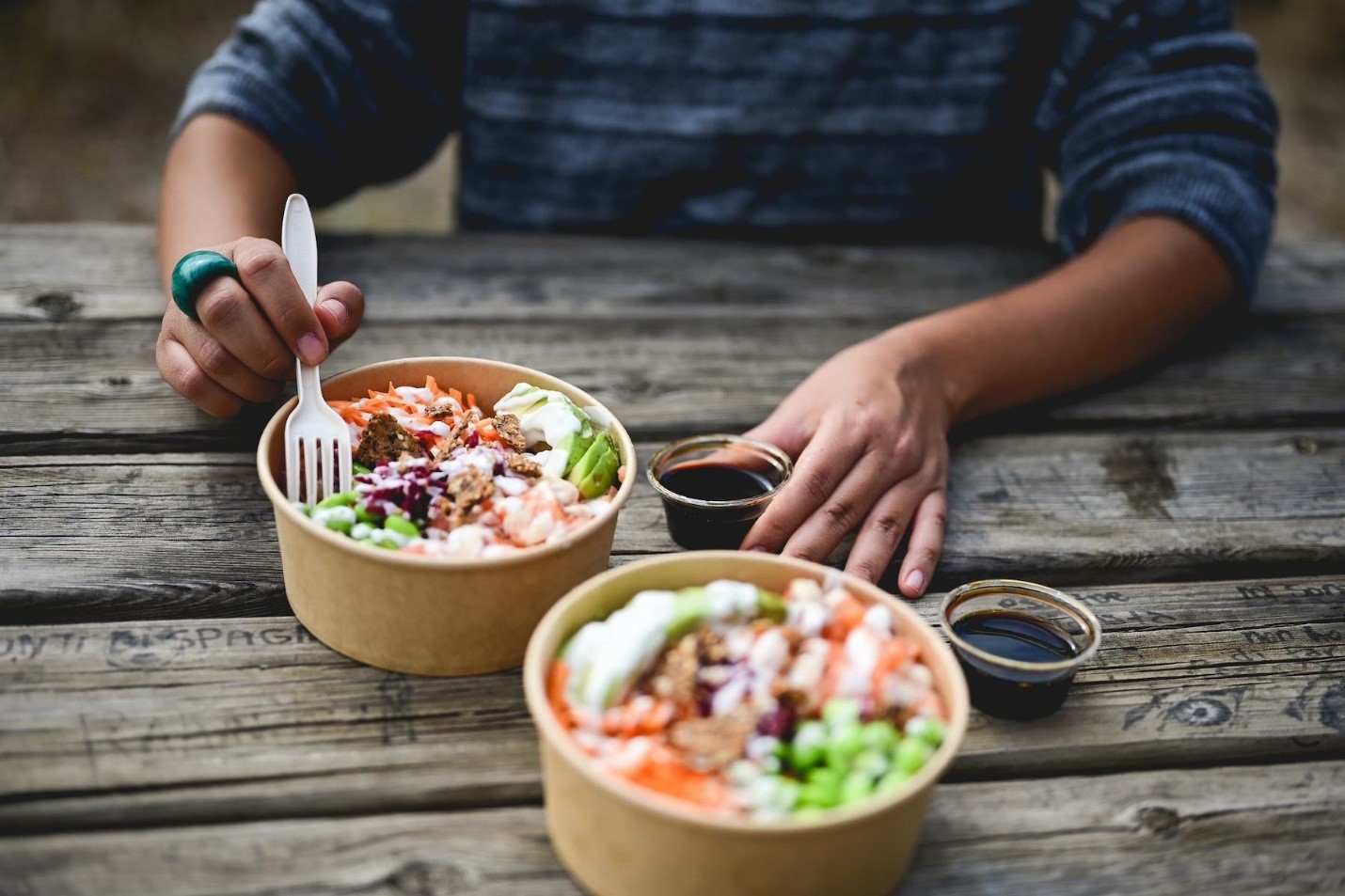 A person eating food at a table

Description automatically generated