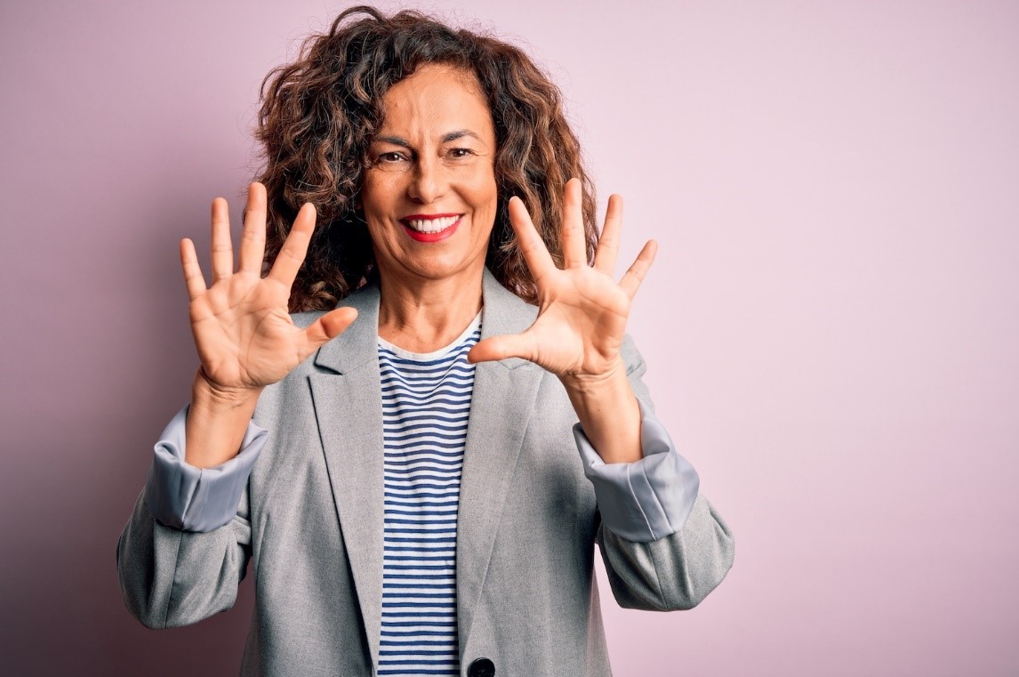 A person holding her hands up

Description automatically generated